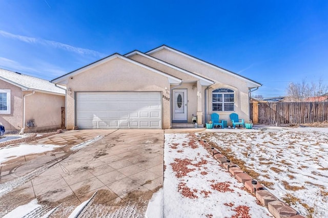 ranch-style house with fence, driveway, an attached garage, and stucco siding