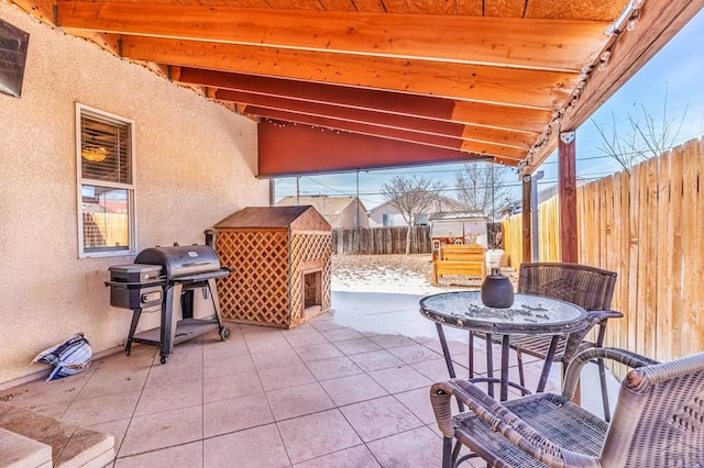 view of patio with a grill, a fireplace, and a fenced backyard