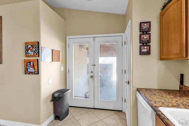 entryway featuring light tile patterned floors, french doors, a wealth of natural light, and baseboards