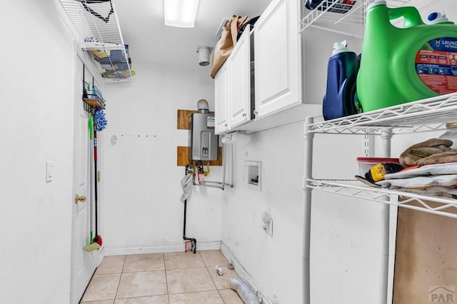 laundry room with water heater, washer hookup, light tile patterned flooring, and cabinet space