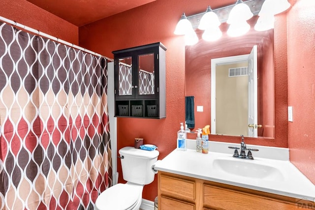 full bath featuring visible vents, a textured wall, vanity, and toilet