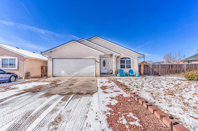 single story home featuring concrete driveway, an attached garage, fence, and stucco siding