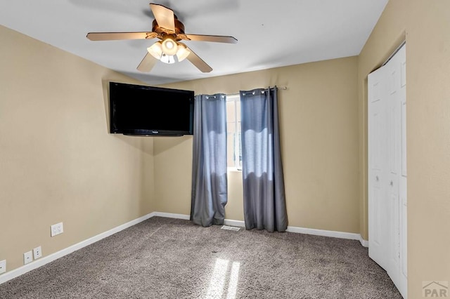 unfurnished bedroom with carpet floors, a ceiling fan, and baseboards