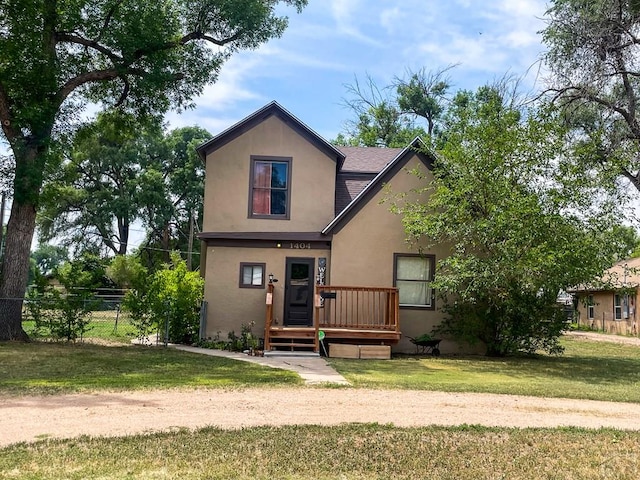 view of front of home featuring a front yard, fence, a wooden deck, and stucco siding