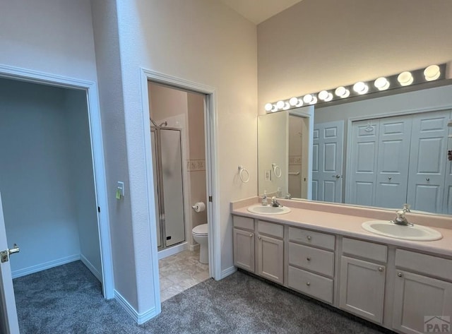 165 Kingsley Ave Unit M, Pueblo, CO 81005 - bathroom featuring toilet, a stall shower, double vanity, and baseboards