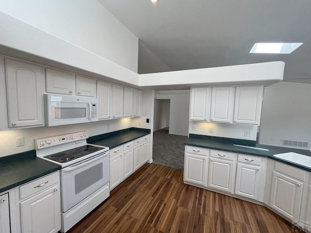 165 Kingsley Ave Unit M, Pueblo, CO 81005 - kitchen featuring white appliances, dark countertops, dark wood-type flooring, a sink, and high vaulted ceiling