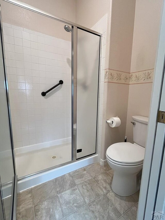 165 Kingsley Ave Unit M, Pueblo, CO 81005 - bathroom with a shower stall, toilet, and tile patterned flooring