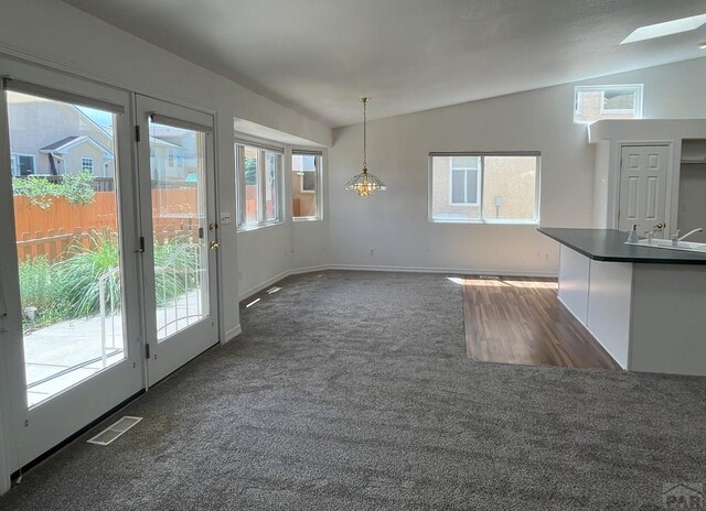 165 Kingsley Ave Unit M, Pueblo, CO 81005 - unfurnished dining area with lofted ceiling, dark carpet, a sink, and baseboards