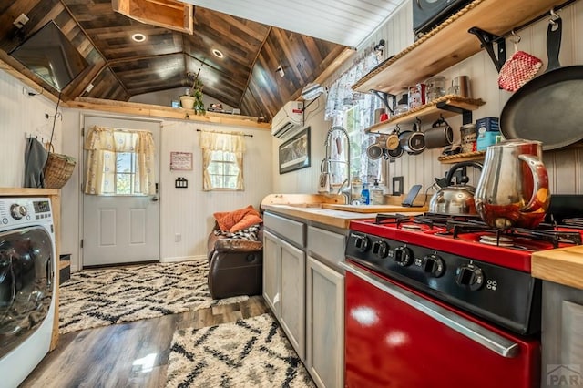 9016 Pine Ave, Beulah, CO 81023 - kitchen with stove, a sink, vaulted ceiling, wood finished floors, and washer / dryer