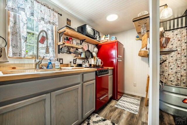 9016 Pine Ave, Beulah, CO 81023 - kitchen with gray cabinets, dark wood-style floors, open shelves, gas range, and a sink