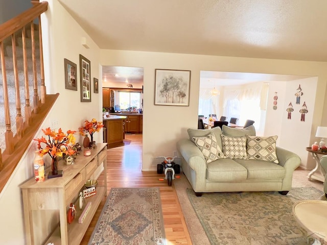 living area featuring light wood-type flooring and stairs