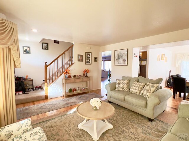 living room featuring recessed lighting, stairway, and wood finished floors