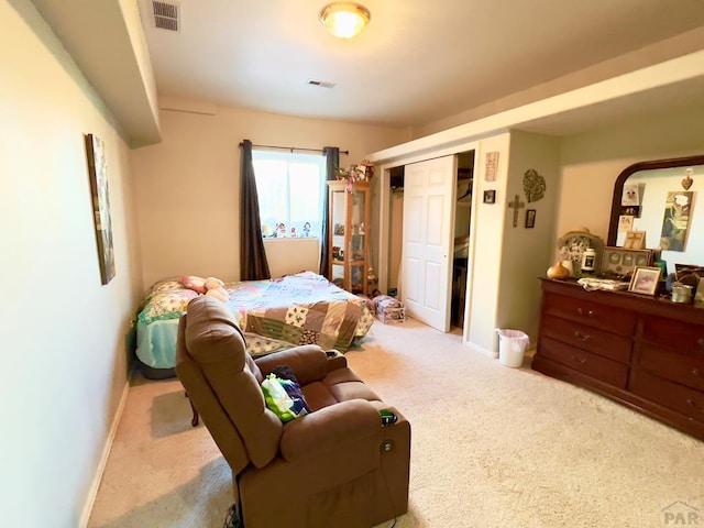 bedroom featuring visible vents, light carpet, and baseboards