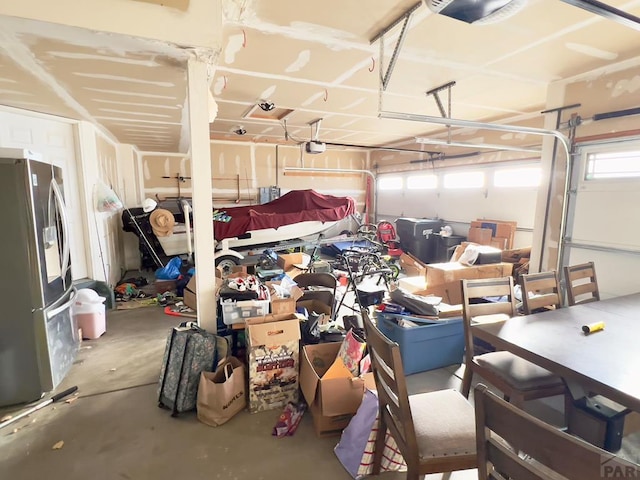 garage with a garage door opener and freestanding refrigerator