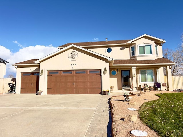 traditional-style home featuring concrete driveway, fence, an attached garage, and stucco siding