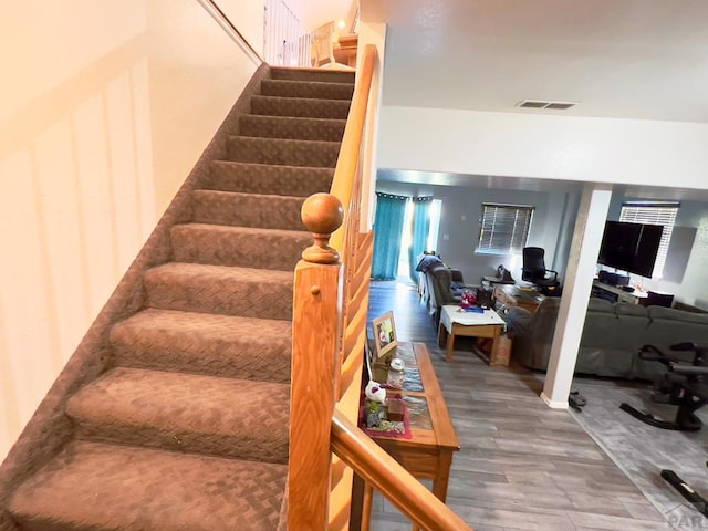 stairway with wood finished floors and visible vents