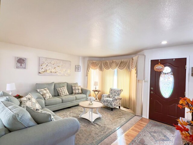 living room with a textured ceiling, wood finished floors, and recessed lighting