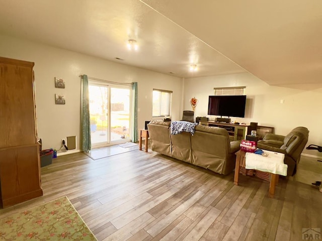 living area featuring light wood-style flooring and baseboards