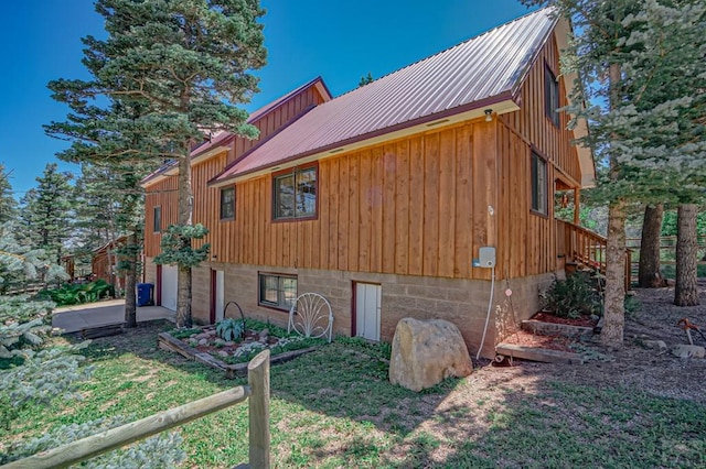 view of side of home with metal roof and a lawn