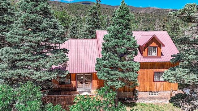 view of front of home with french doors, metal roof, and a mountain view