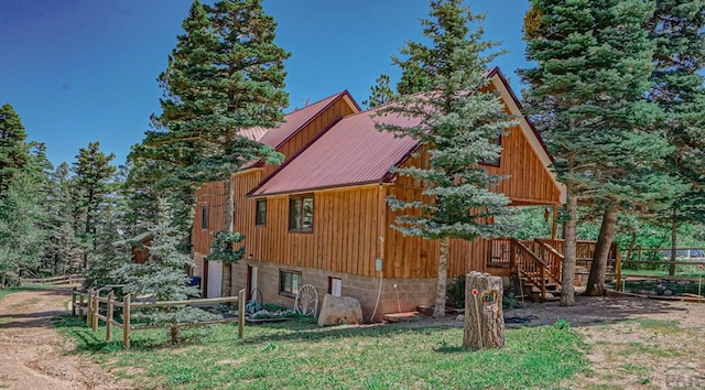 view of home's exterior with fence and metal roof