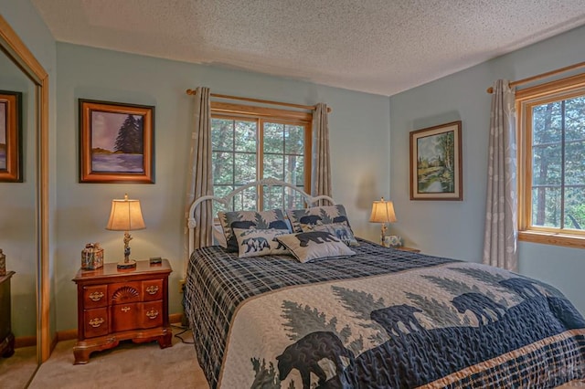 bedroom featuring baseboards, a textured ceiling, and light colored carpet