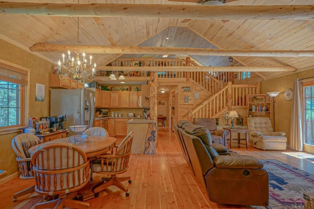 dining area with a healthy amount of sunlight, light wood-style flooring, lofted ceiling with beams, and a notable chandelier