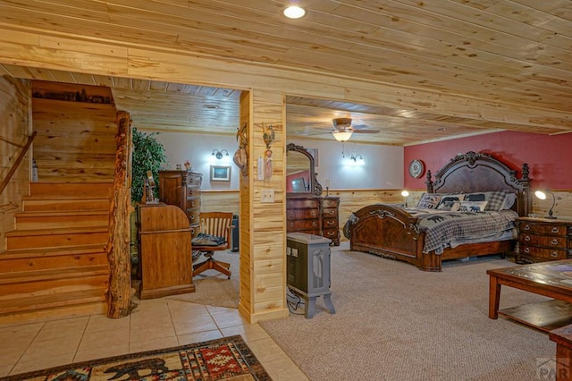 bedroom with light carpet, wooden ceiling, light tile patterned floors, and wainscoting