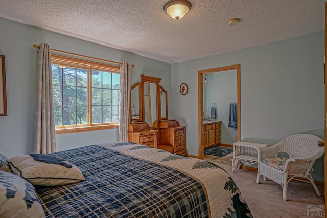 bedroom featuring ensuite bath, baseboards, a textured ceiling, and light colored carpet