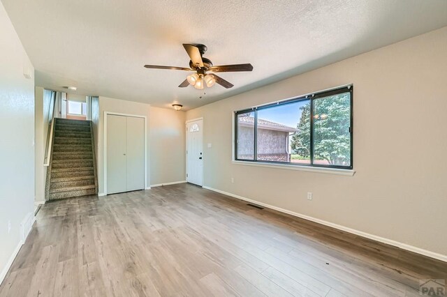 950 S Los Charros Dr, Pueblo West, CO 81007 - empty room with stairway, ceiling fan, and wood finished floors
