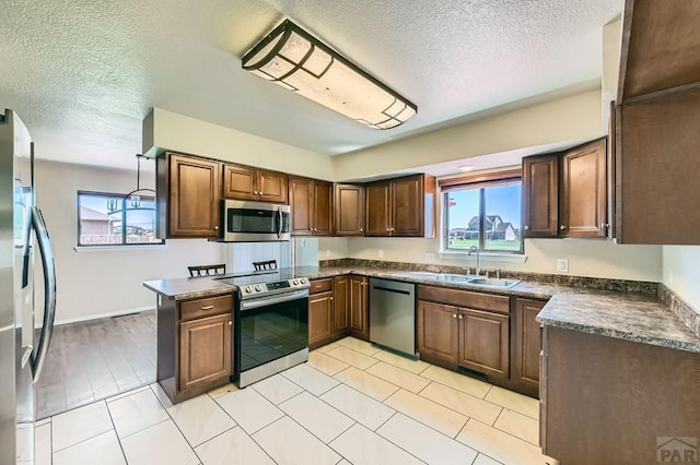 950 S Los Charros Dr, Pueblo West, CO 81007 - kitchen with appliances with stainless steel finishes, dark countertops, plenty of natural light, and a textured ceiling