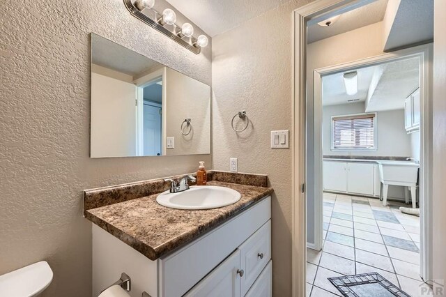 950 S Los Charros Dr, Pueblo West, CO 81007 - bathroom featuring a textured wall, vanity, and tile patterned flooring