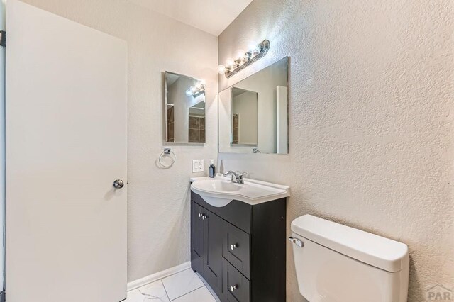 950 S Los Charros Dr, Pueblo West, CO 81007 - bathroom with vanity, marble look tile flooring, and a textured wall