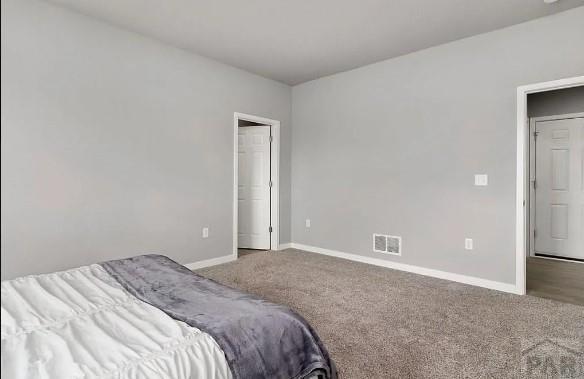 carpeted bedroom with visible vents and baseboards