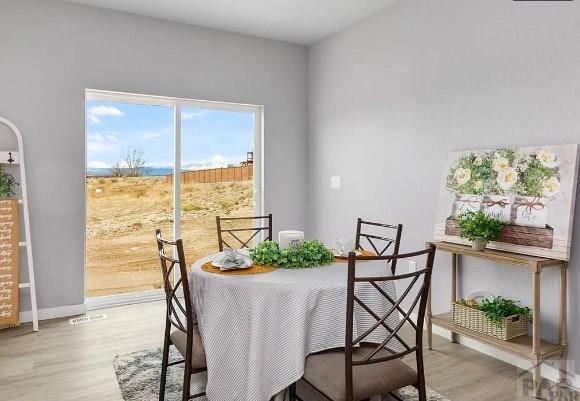 dining area with light wood-style flooring and baseboards