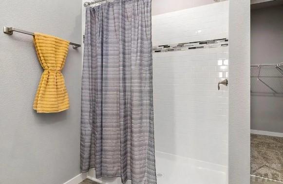 full bathroom with a shower with shower curtain and baseboards