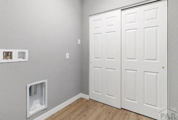 laundry area featuring laundry area, hookup for a washing machine, baseboards, and light wood-type flooring