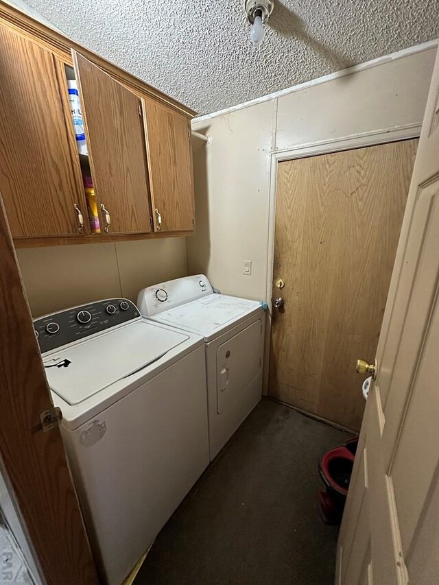 clothes washing area featuring cabinet space, a textured ceiling, and independent washer and dryer