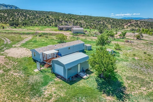 drone / aerial view with a wooded view and a mountain view