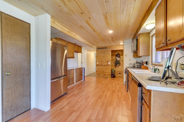 kitchen with wooden ceiling, appliances with stainless steel finishes, brown cabinets, light countertops, and a sink