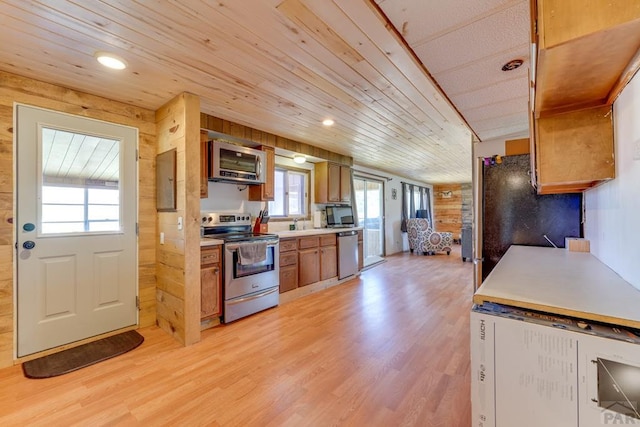 kitchen with wooden ceiling, appliances with stainless steel finishes, brown cabinets, light countertops, and light wood-type flooring