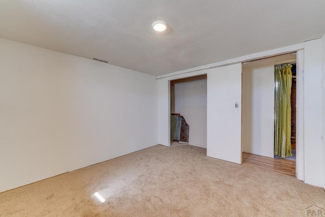 unfurnished bedroom featuring a closet, light carpet, and visible vents