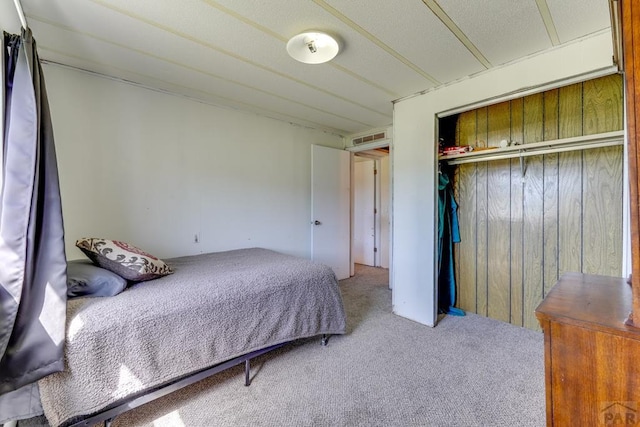 bedroom featuring a closet, visible vents, and carpet flooring