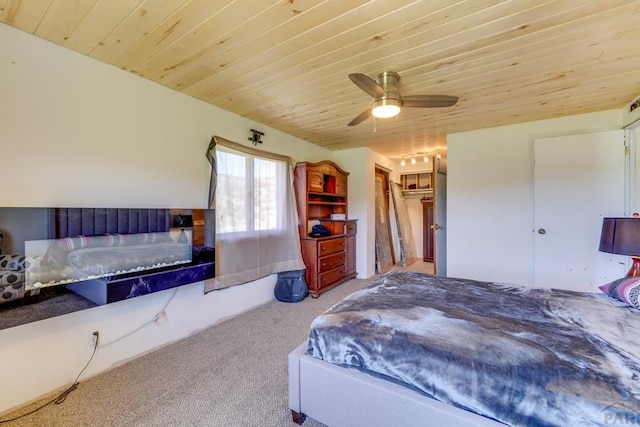 bedroom featuring wood ceiling, a fireplace, ceiling fan, and carpet flooring