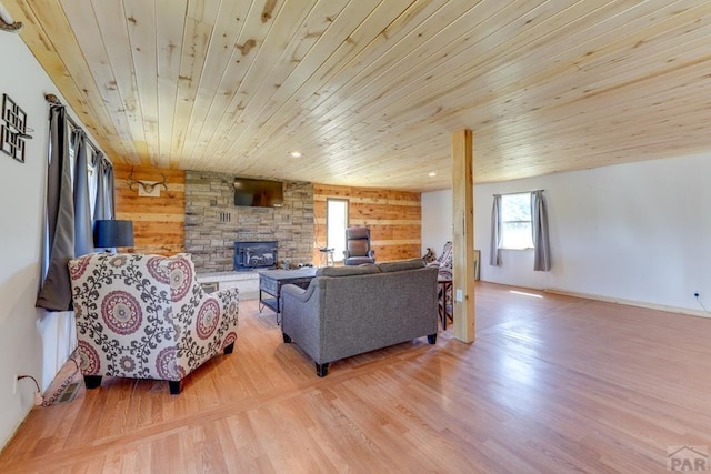 living room with recessed lighting, light wood finished floors, wood ceiling, and wood walls