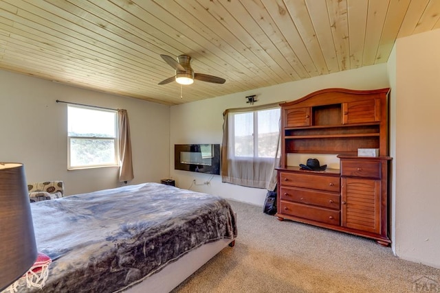 bedroom with wood ceiling, a ceiling fan, and light colored carpet