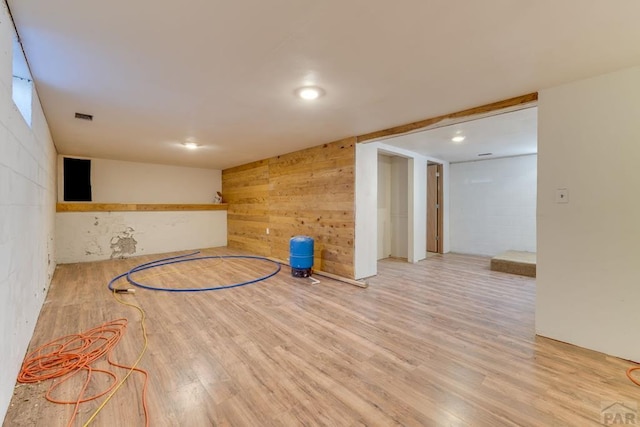 interior space featuring basketball hoop, wooden walls, visible vents, and light wood-style floors