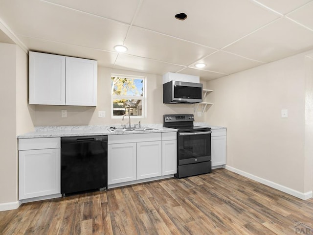 1415 E 2nd St, Pueblo, CO 81001 - kitchen featuring black appliances, a sink, wood finished floors, white cabinetry, and recessed lighting