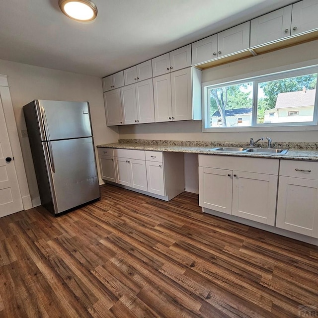 1938 E 6th St, Pueblo, CO 81001 - kitchen featuring freestanding refrigerator, dark wood-style floors, and white cabinets