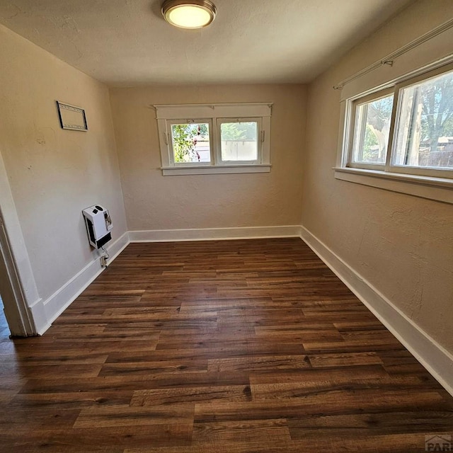 1938 E 6th St, Pueblo, CO 81001 - unfurnished room with plenty of natural light, dark wood-style flooring, and heating unit